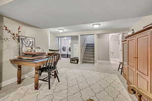 Office space with light colored carpet, a textured ceiling, and independent washer and dryer