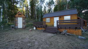 View of front of property with a metal roof and an outdoor structure