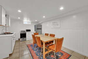 Dining room with wainscoting, recessed lighting, and light tile patterned floors