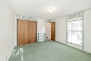 Unfurnished bedroom with a textured ceiling, carpet floors, and a closet