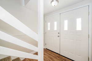 Foyer entrance featuring wood finished floors and stairs