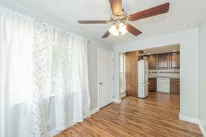 Unfurnished dining area featuring dark wood finished floors and ceiling fan