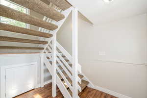 Stairway featuring wood finished floors and baseboards