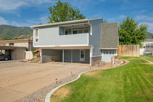 View of front facade featuring concrete driveway, a mountain view, a balcony, and roof with shingles