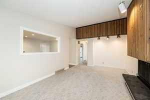 Unfurnished living room with light colored carpet and a textured ceiling