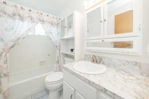 Full bath featuring shower / bath combination with curtain, vanity, and tile patterned floors