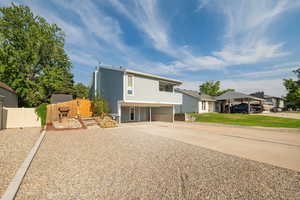 View of front of property with driveway and a carport