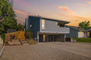 View of front of house with driveway, a carport, and a gate