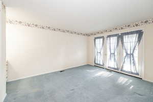 Unfurnished room featuring carpet and a textured ceiling