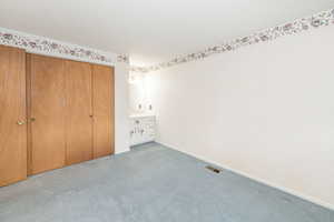 Unfurnished bedroom with carpet floors, a textured ceiling, and a closet