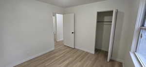 Unfurnished bedroom with light wood-type flooring and a closet