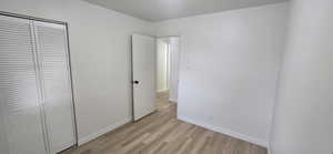 Unfurnished bedroom with a closet and light wood-style flooring