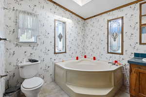 Full bath featuring ornamental molding, vanity, a bath, a textured ceiling, and wallpapered walls