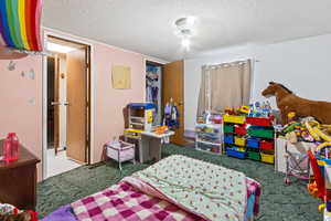 Bedroom with a textured ceiling and carpet