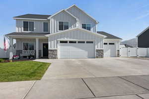 Modern inspired farmhouse featuring board and batten siding, a gate, a garage, and driveway