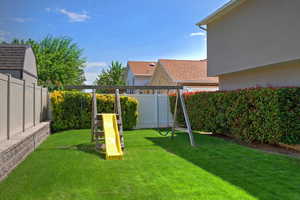 Fenced backyard with a playground