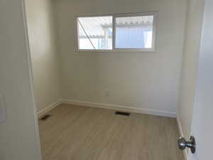 Empty room featuring light wood finished floors and baseboards