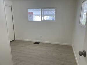 Unfurnished bedroom with wood finished floors and multiple windows