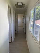 Hallway with light wood finished floors and baseboards