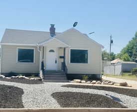 Bungalow featuring a chimney and roof with shingles