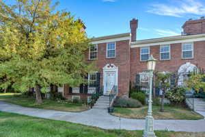 Colonial inspired home with a chimney, a front yard, and brick siding