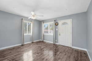 Entrance foyer with wood finished floors and a ceiling fan
