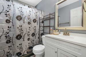 Full bath featuring vanity and curtained shower