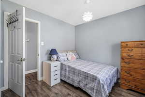 Bedroom with dark wood finished floors and baseboards
