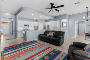 Living area featuring a ceiling fan, a chandelier, recessed lighting, and light tile patterned floors
