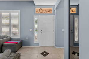 Entryway with healthy amount of natural light and light tile patterned flooring