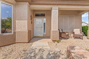 Doorway to property featuring stucco siding and a porch