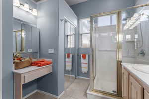 Bathroom featuring vanity, a stall shower, and tile patterned flooring