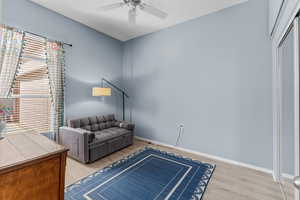 Living room featuring light wood-style flooring and baseboards