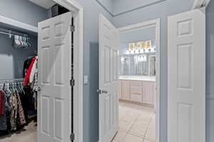 Bathroom with tile patterned flooring, vanity, and a spacious closet
