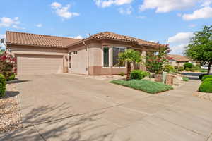 Mediterranean / spanish-style home with stucco siding, an attached garage, concrete driveway, and a tile roof