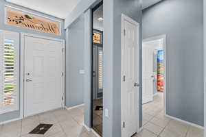 Entrance foyer featuring light tile patterned floors and baseboards