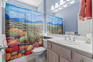 Bathroom with vanity, tile patterned floors, and a shower with shower curtain