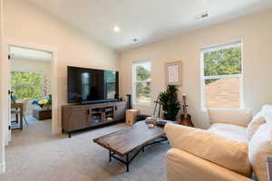 Living area with vaulted ceiling, carpet flooring, healthy amount of natural light, and recessed lighting