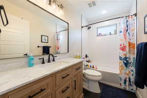 Bathroom with vanity and shower / bath combination with curtain
