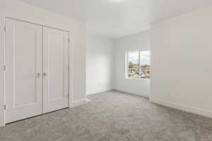 Unfurnished bedroom featuring carpet floors and a closet