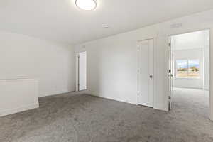 Unfurnished room featuring carpet and a textured ceiling