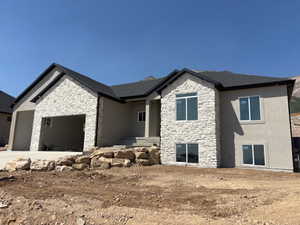View of front of home featuring stone siding and an attached garage