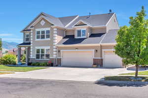 View of front of home featuring brick siding, concrete driveway, stucco siding, and a shingled roof