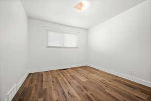 Unfurnished room featuring wood finished floors and baseboards