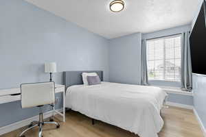 Bedroom featuring wood finished floors and a textured ceiling