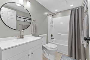 Full bathroom with shower / tub combo, vanity, tile patterned floors, and recessed lighting