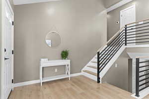 Foyer entrance featuring wood finished floors and stairs