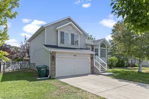 Traditional-style house with a garage, driveway, and brick siding