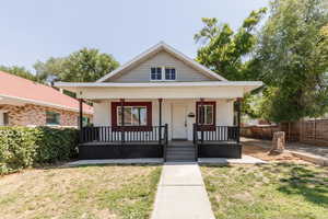 Bungalow-style house featuring a front yard, brick siding, and a porch
