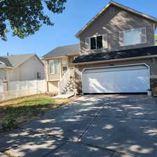 View of front of home with an attached garage and concrete driveway